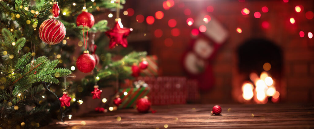 Christmas Tree with Decorations Near a Fireplace with Lights